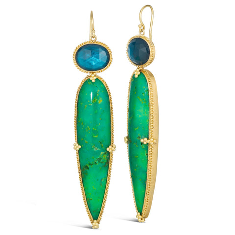 This pair of earrings features an oval shaped blue topaz stone atop an elongated teardrop shaped bright green turquoise stone. The stones are set in 18k yellow gold chain wrapped bezels with beaded prongs that hang on French hook closures.
