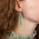 A model wears a long Amazonite stone earring wrapped in delicate gold chains that hangs from a French hook closure.