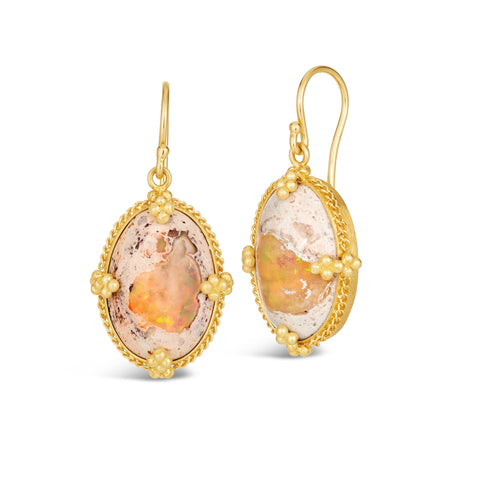 This pair of oval shaped Mexican opal earrings feature chain wrapped bezels with four beaded prongs. The stones hang from French hook closures.
