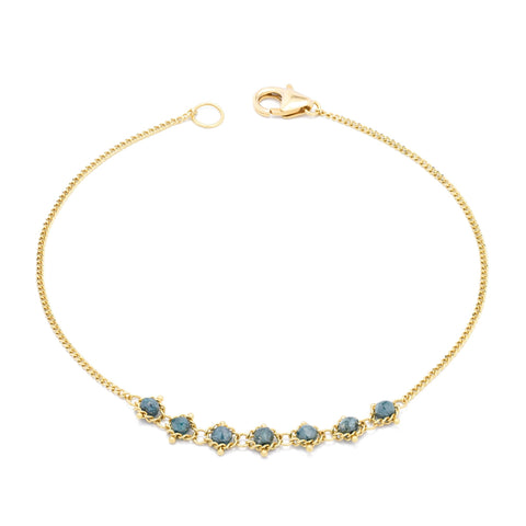 This delicate 18k yellow gold chain bracelet features a row of woven blue diamonds in the center and closes with a lobster clasp.