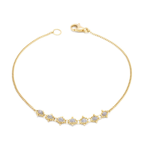 This delicate 18k yellow gold chain bracelet features a row of woven silver diamonds in the center and closes with a lobster clasp.