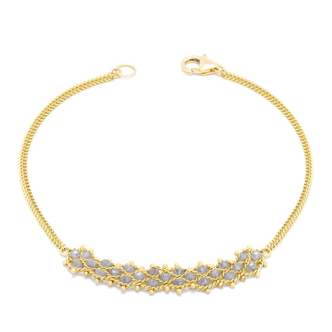 This delicate 18k yellow gold chain bracelet features three rows of woven silver diamonds in the center. The bracelet is finished with a lobster clasp closure.