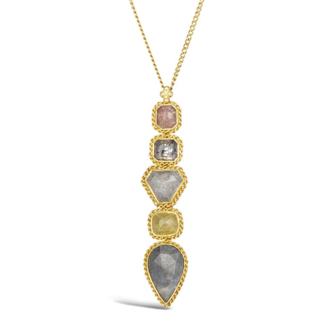 A pendant with five irregular shaped diamonds are set in 18k yellow gold chain wrapped bezels to create a long stick. The pendant hangs on a delicate chain.