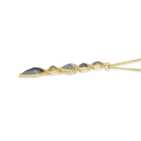 A side view of a diamond pendant, with five stones, is set in an 18k yellow gold chain wrapped bezel. 