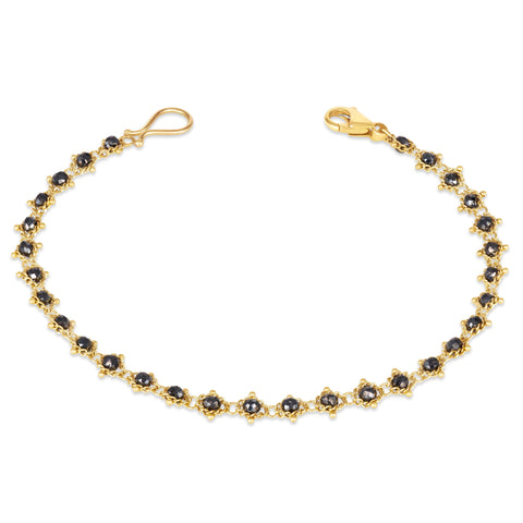 This 18k yellow gold bracelet features black diamond beads woven throughout a delicate chain. The bracelet features a lobster clasp closure.