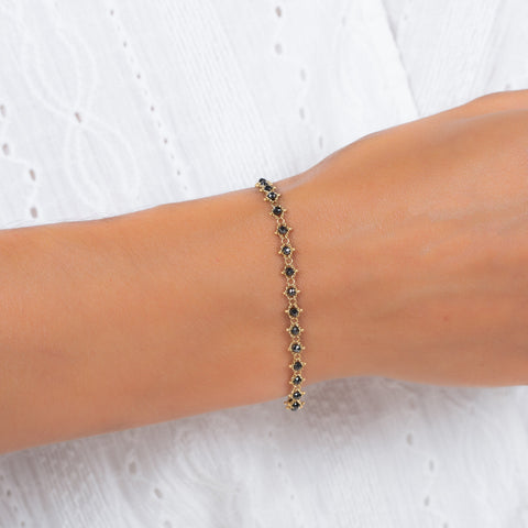 This 18k yellow gold bracelet features black diamond beads woven throughout a delicate chain.