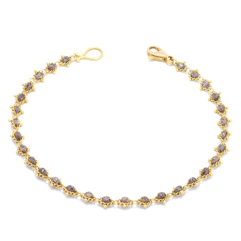 This 18k yellow gold bracelet features champagne diamond beads woven throughout a delicate chain. The bracelet features a lobster clasp closure.