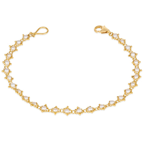 This 18k yellow gold bracelet features white pearl  beads woven throughout a delicate chain. The bracelet features a lobster clasp closure.