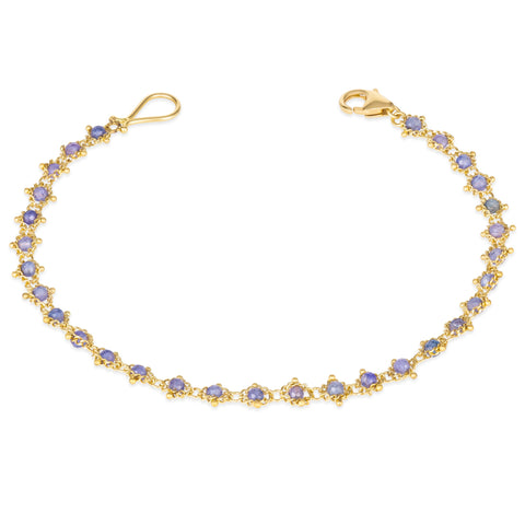 This 18k yellow gold bracelet features tanzanite beads woven throughout a delicate chain. The bracelet features a lobster clasp closure.