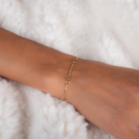 This delicate 18k yellow gold chain bracelet is dotted with champagne diamond beads throughout. The bracelet is finished with a lobster clasp closure.