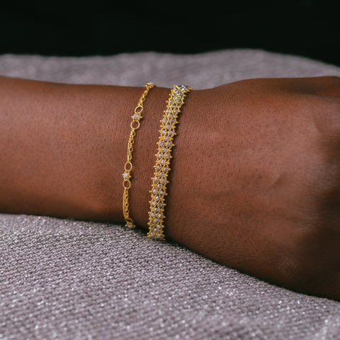 This delicate 18k yellow gold chain bracelet is dotted with silver diamond beads throughout. The bracelet is finished with a lobster clasp closure.