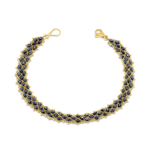 This delicate 18k yellow gold chain bracelet features three rows of woven black diamonds. The bracelet is finished with a lobster clasp closure.