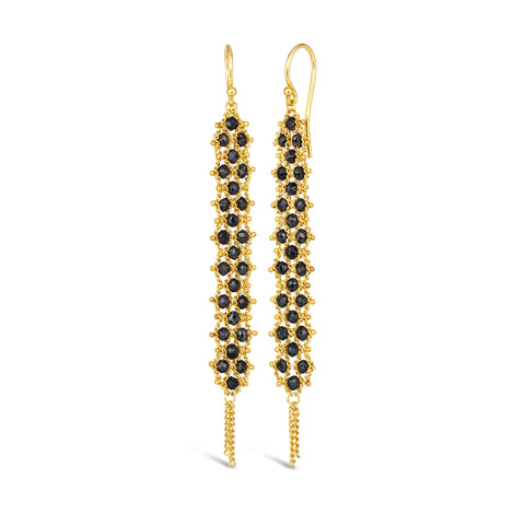 A pair of long black diamond earrings features a woven lattice pattern and two dangling chains at the bottom of the earring. The earrings fasten with french hook closures.