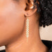 A pair of long grey diamond earrings features a woven lattice pattern and two dangling chains at the bottom of the earring. The earrings fasten with french hook closures.