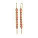 A pair of long red spinel earrings features a woven lattice pattern and two dangling chains at the bottom of the earring. The earrings fasten with french hook closures.